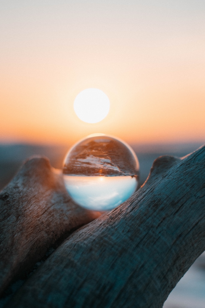 crystal ball in wood with sunset in background