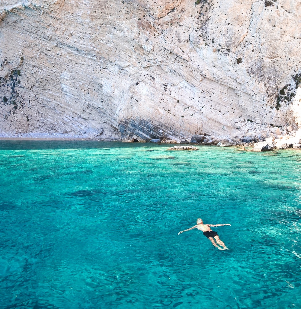 Man floating in blue ocean